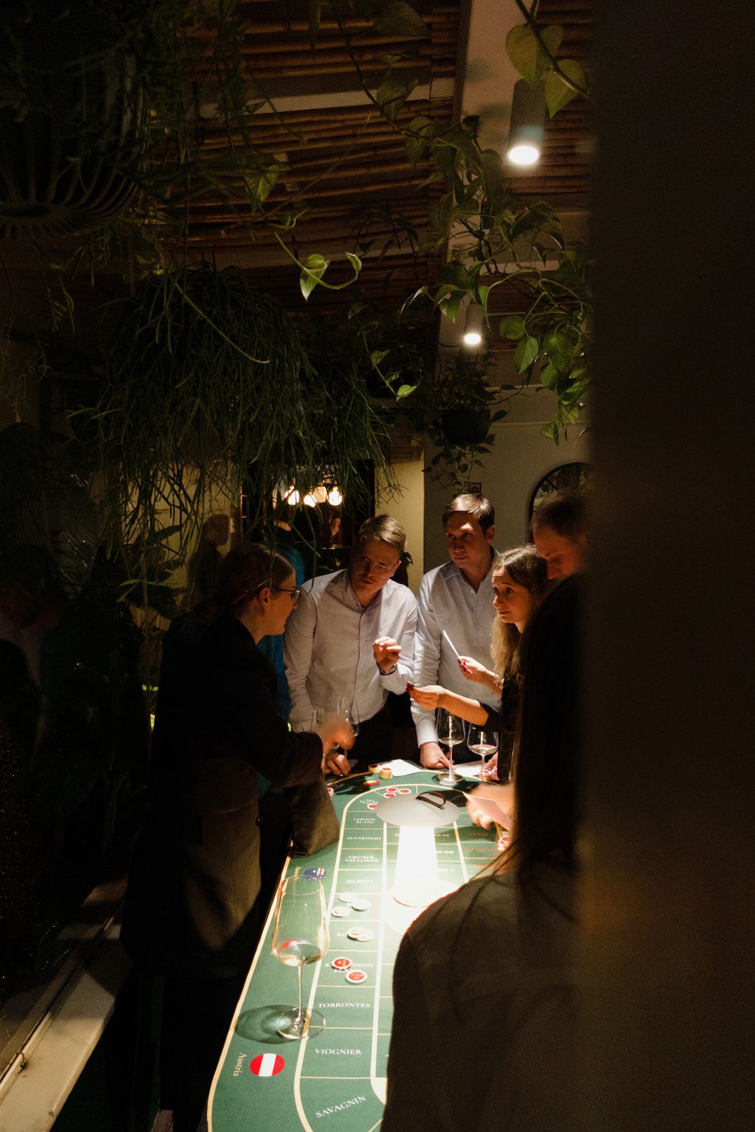 Guests gathered around the Sip Royal tasting table in a plant-filled Lisbon venue